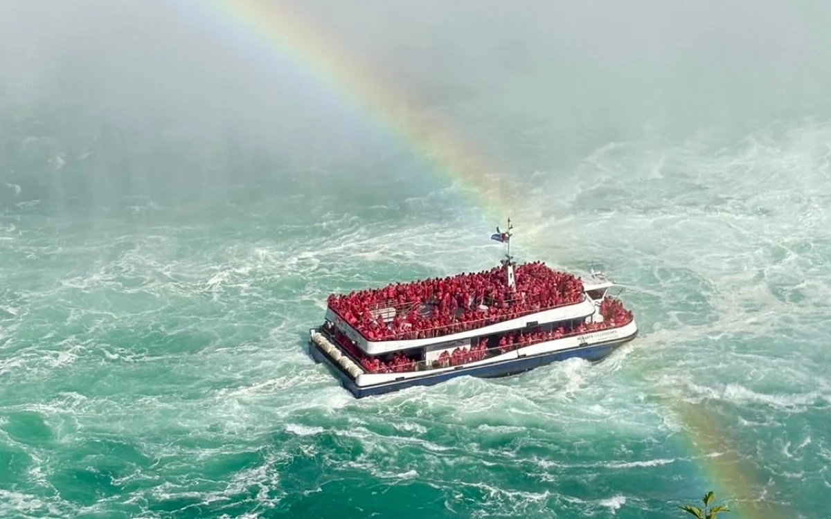 The red-ponchoed deck of a cruise boat approaching the base of Horseshoe Falls